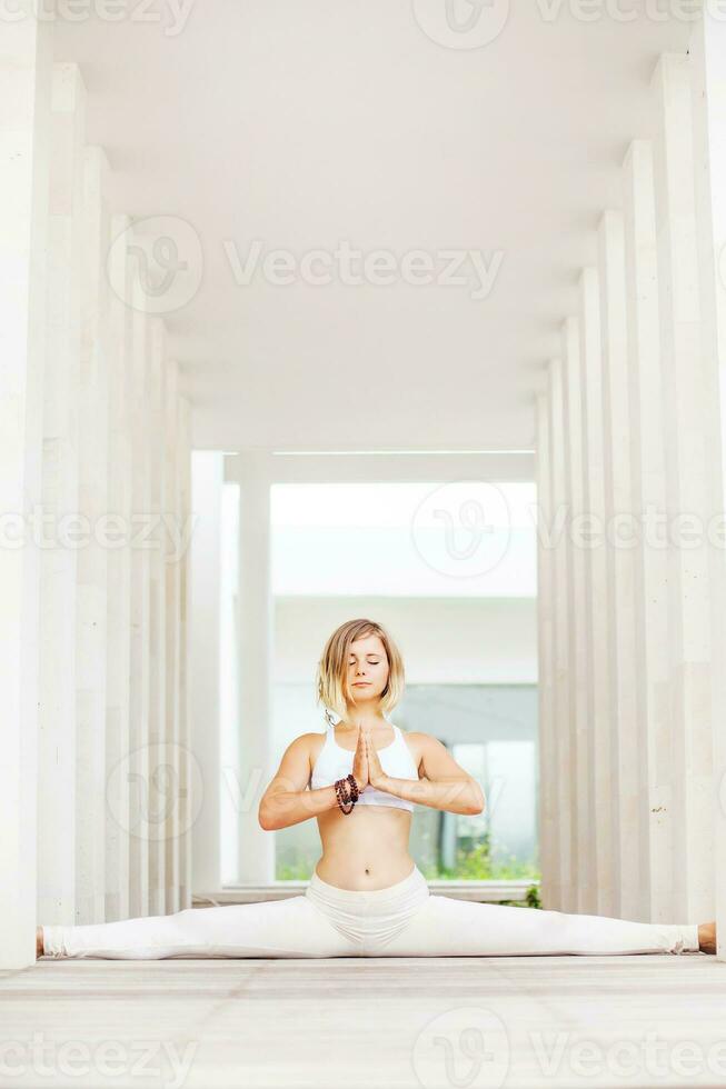 kvinna håller på med yoga asana anjaneyasana i en rymlig studio foto