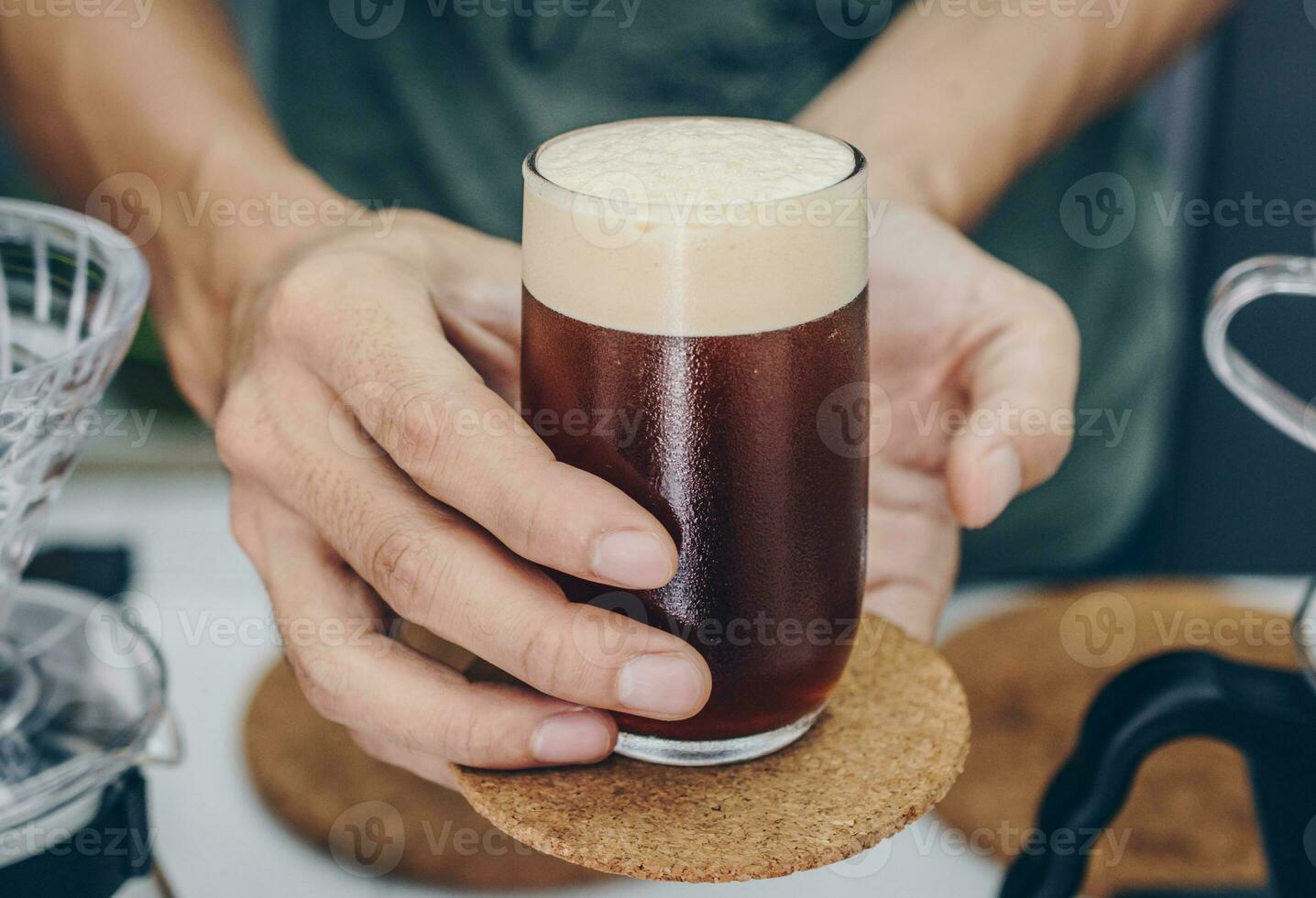 Barista innehav och tjänande en dricka glas av kall brygga dopp kaffe. foto