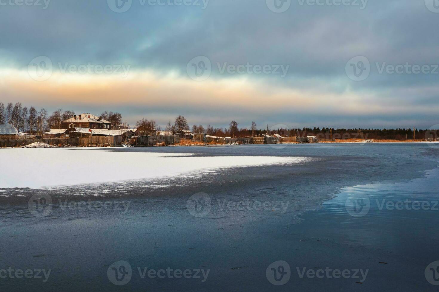 vinter- se med gammal hus nära en snötäckt sjö. äkta nordlig stad av kem i vinter- foto
