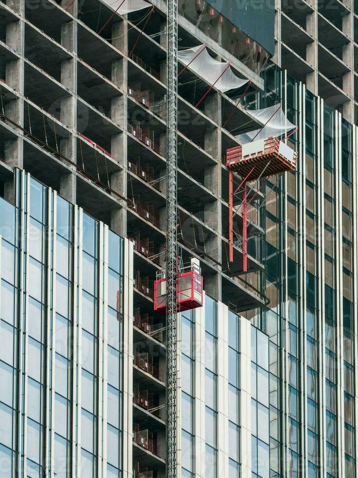 hissar hissar till de konstruktion webbplatser av en skyskrapa under konstruktion. foto