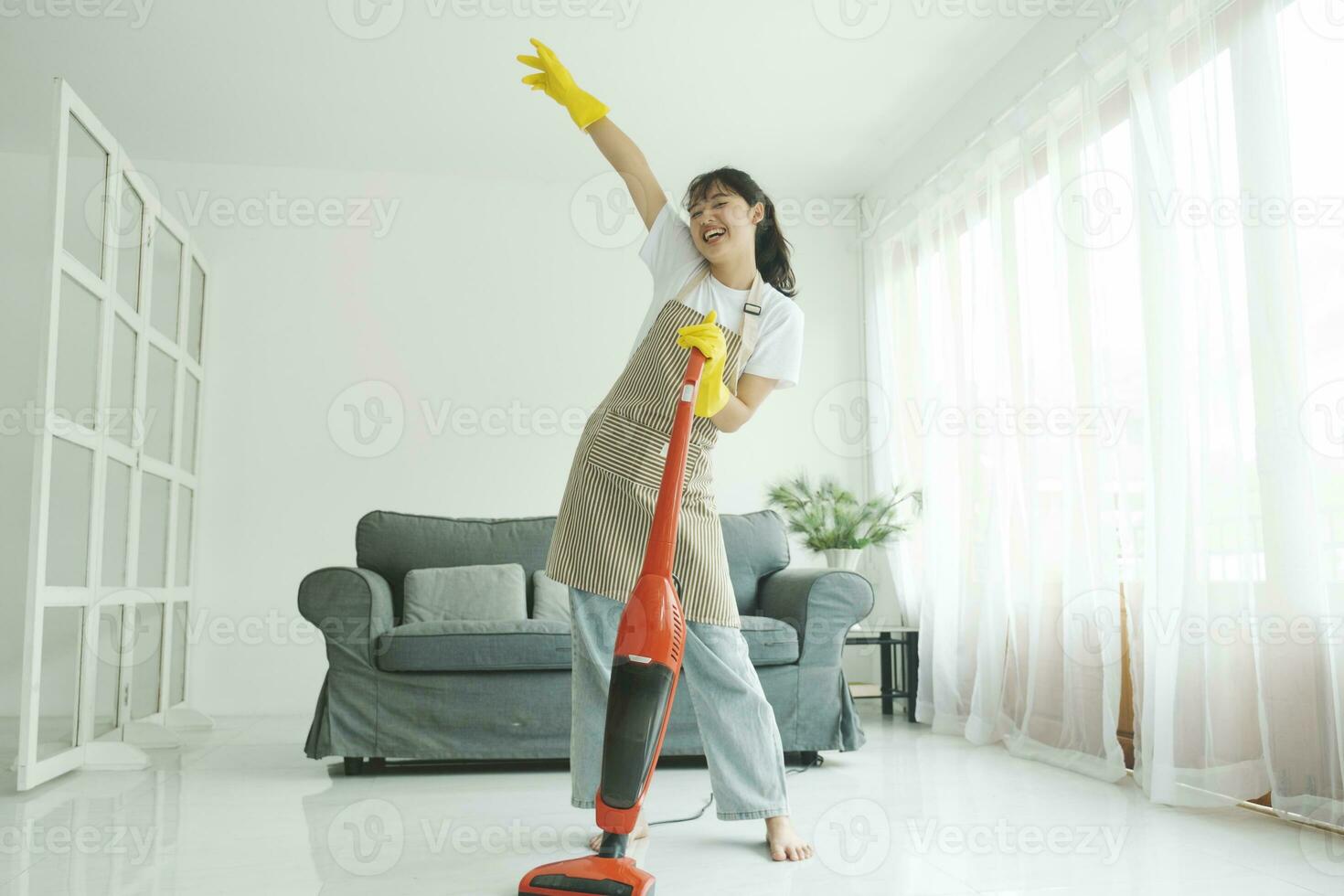 ung kvinna har roligt medan rengöring Hem. foto