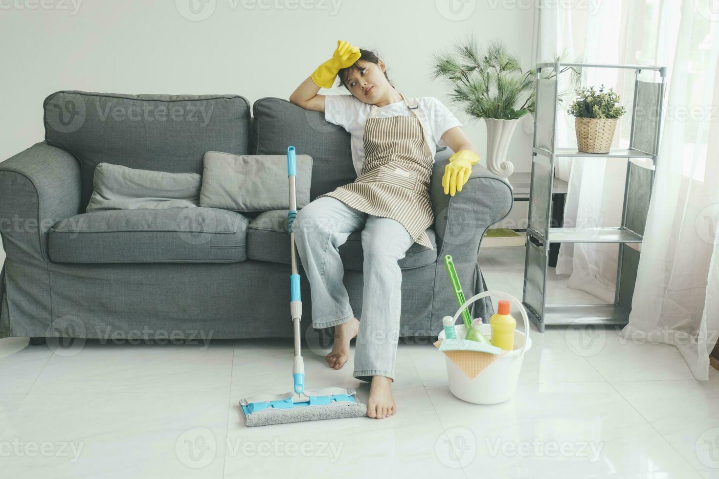 utmattad kvinna vilar efter rengöring Hem. foto