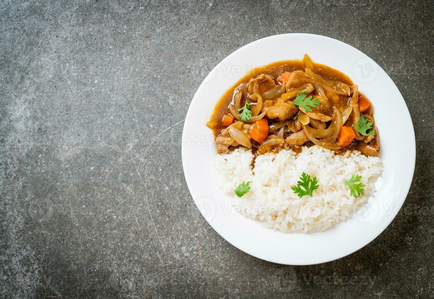 japanskt curryris med skivat fläsk, morot och lök foto