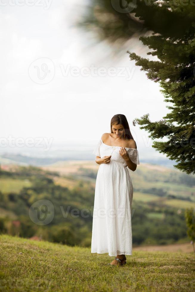 ung gravid kvinna i skogen foto