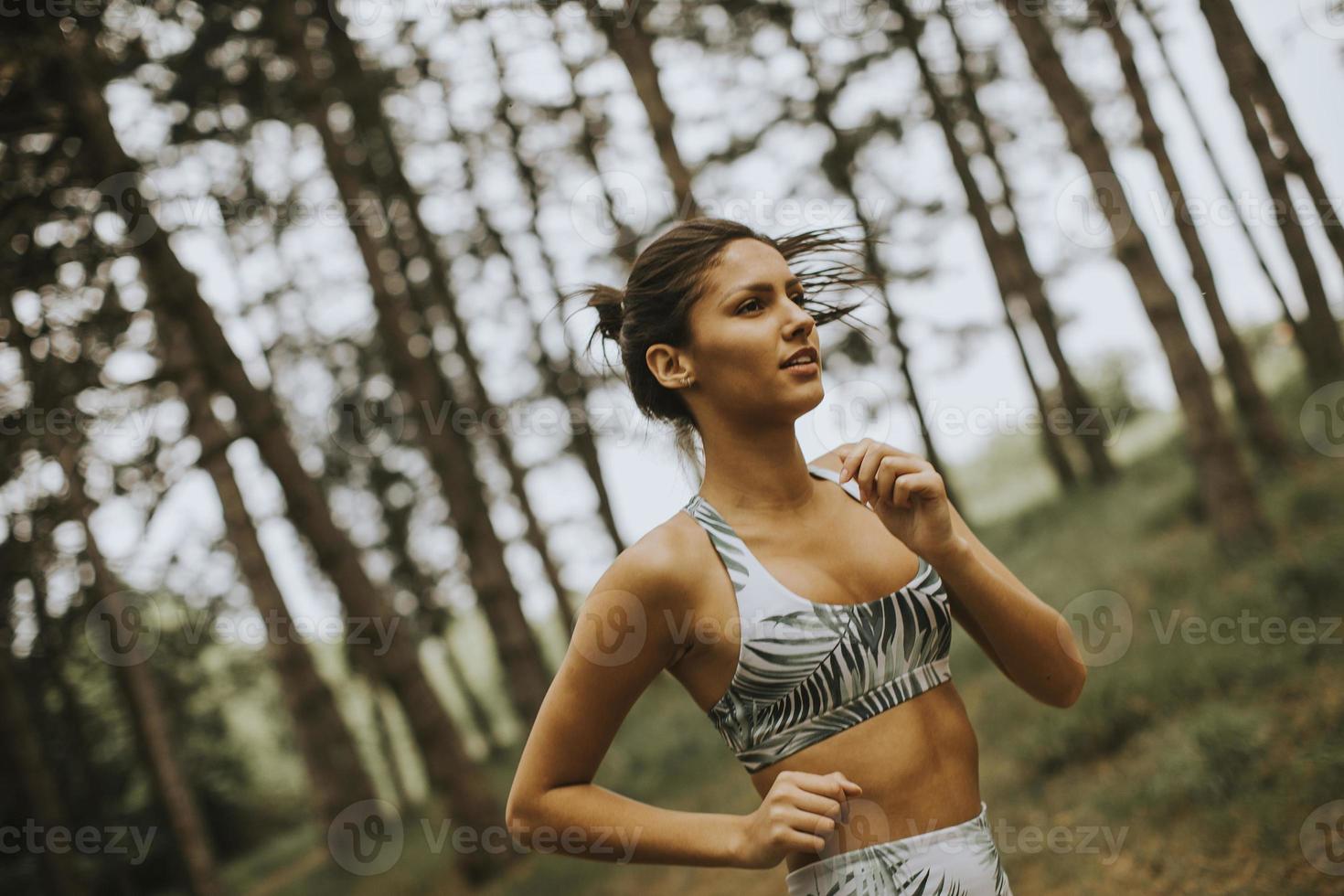 ung fitness kvinna kör på skogsstig foto