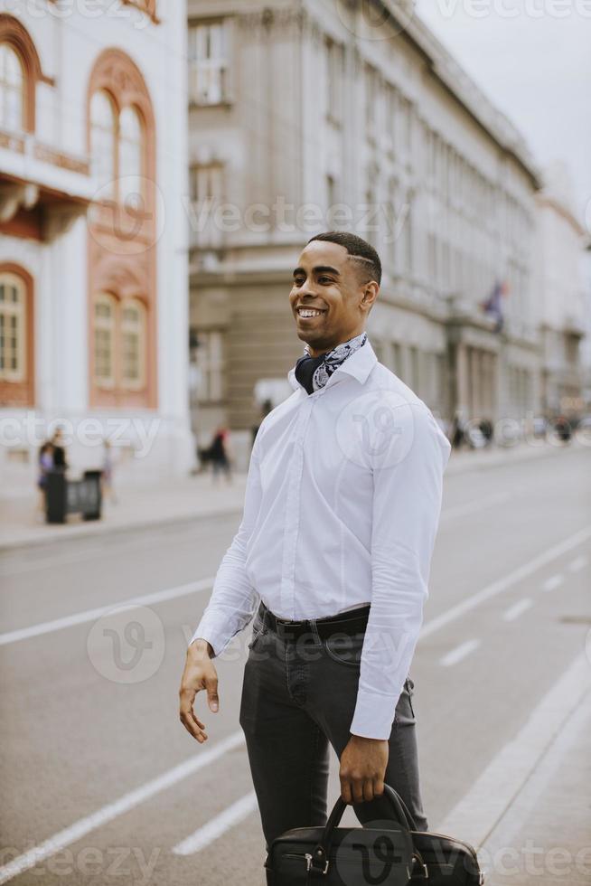 ung afrikansk amerikansk affärsman som väntar en taxi på en gata foto