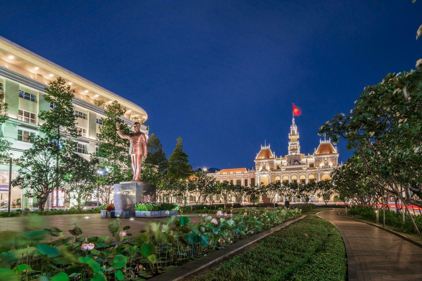 ho chi minh, viet nam - 10 april 2023 saigon stad hall, vincom Centrum torn, färgrik gata trafik och tropisk växter mot de Fantastisk natt. saigon stadens centrum med dess känd landmärken. foto