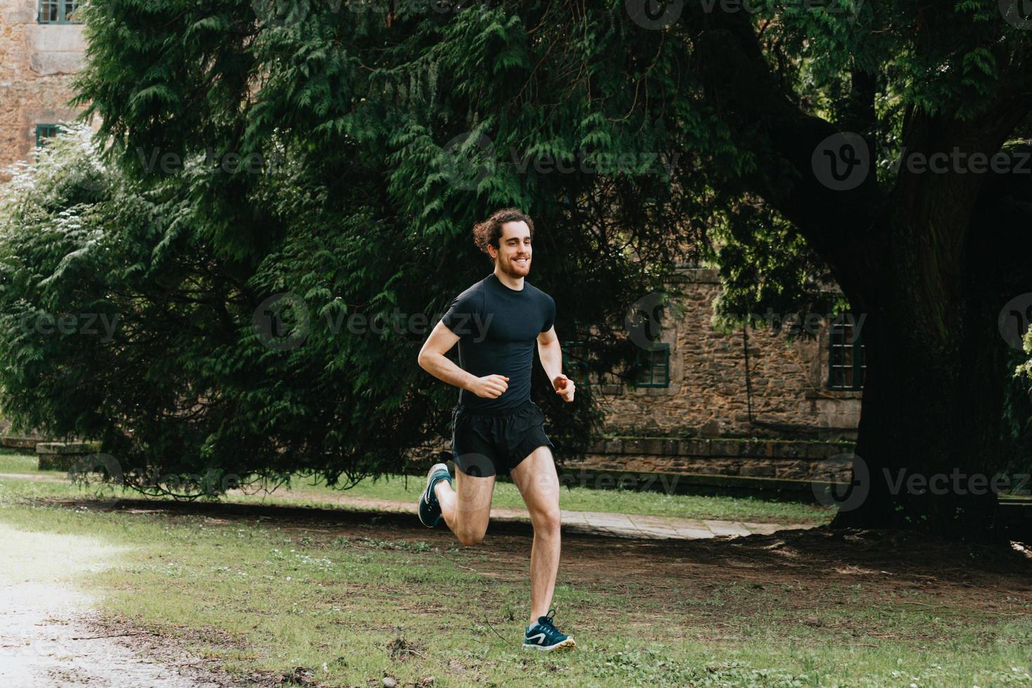 en ung man som gör en sprint i parken under en träningsdag medan du gör kondition foto