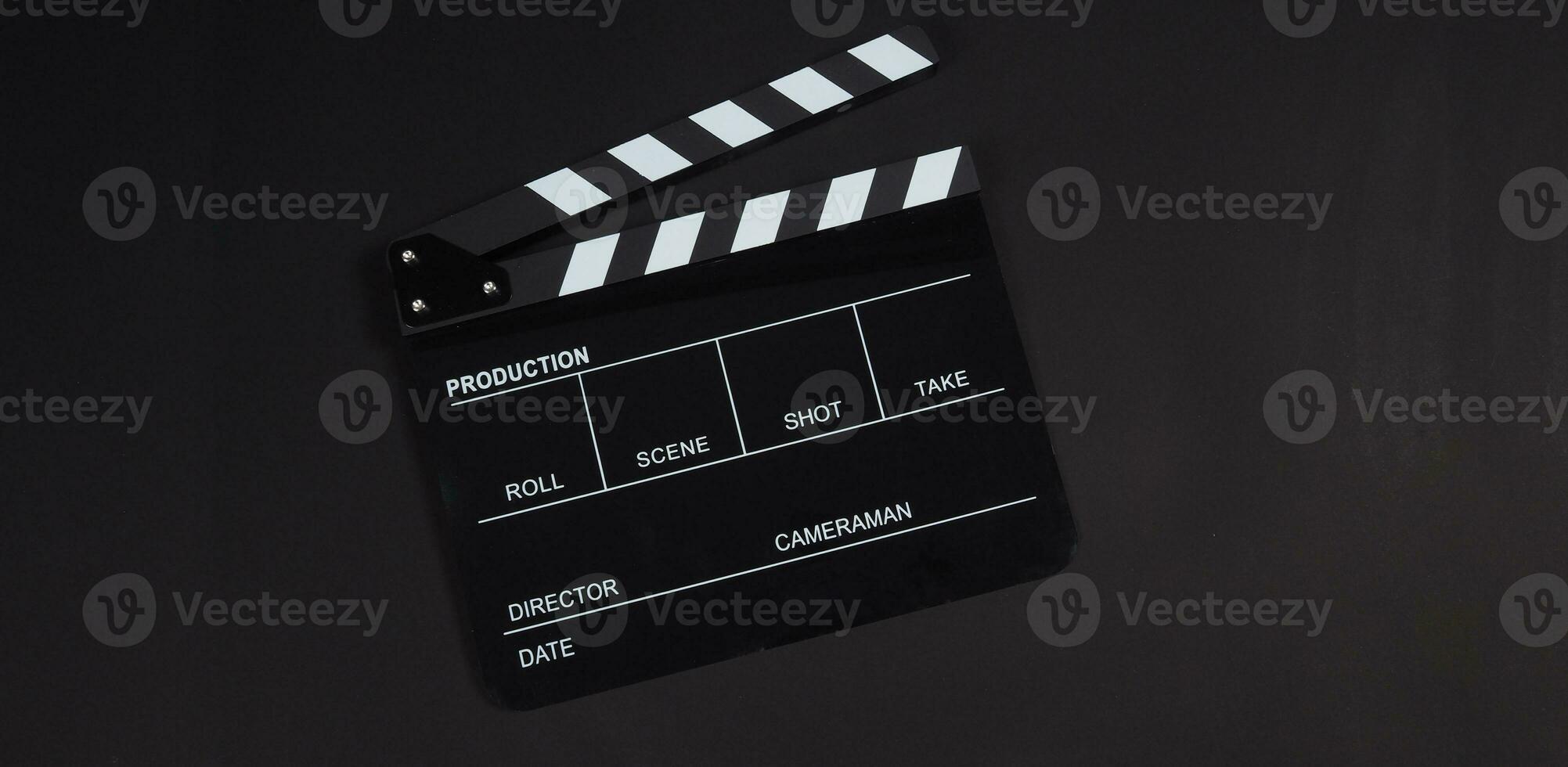 svart clapperboard eller klappa styrelse eller film skiffer använda sig av i video produktion ,filma, bio industri på svart bakgrund. foto