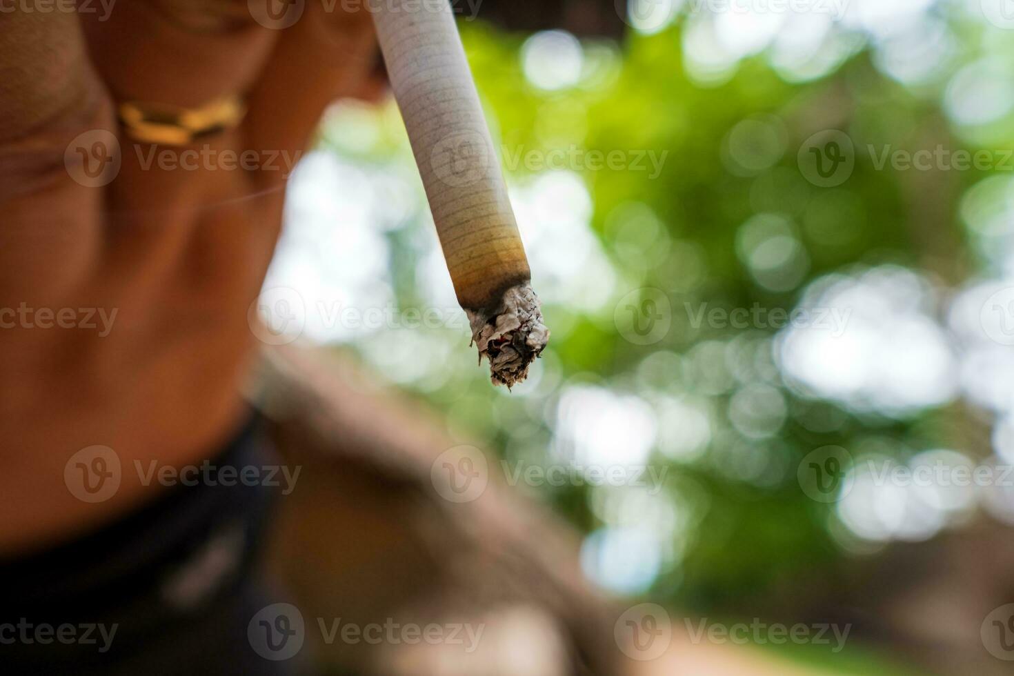 närbild manlig hand som håller en cigarett. foto