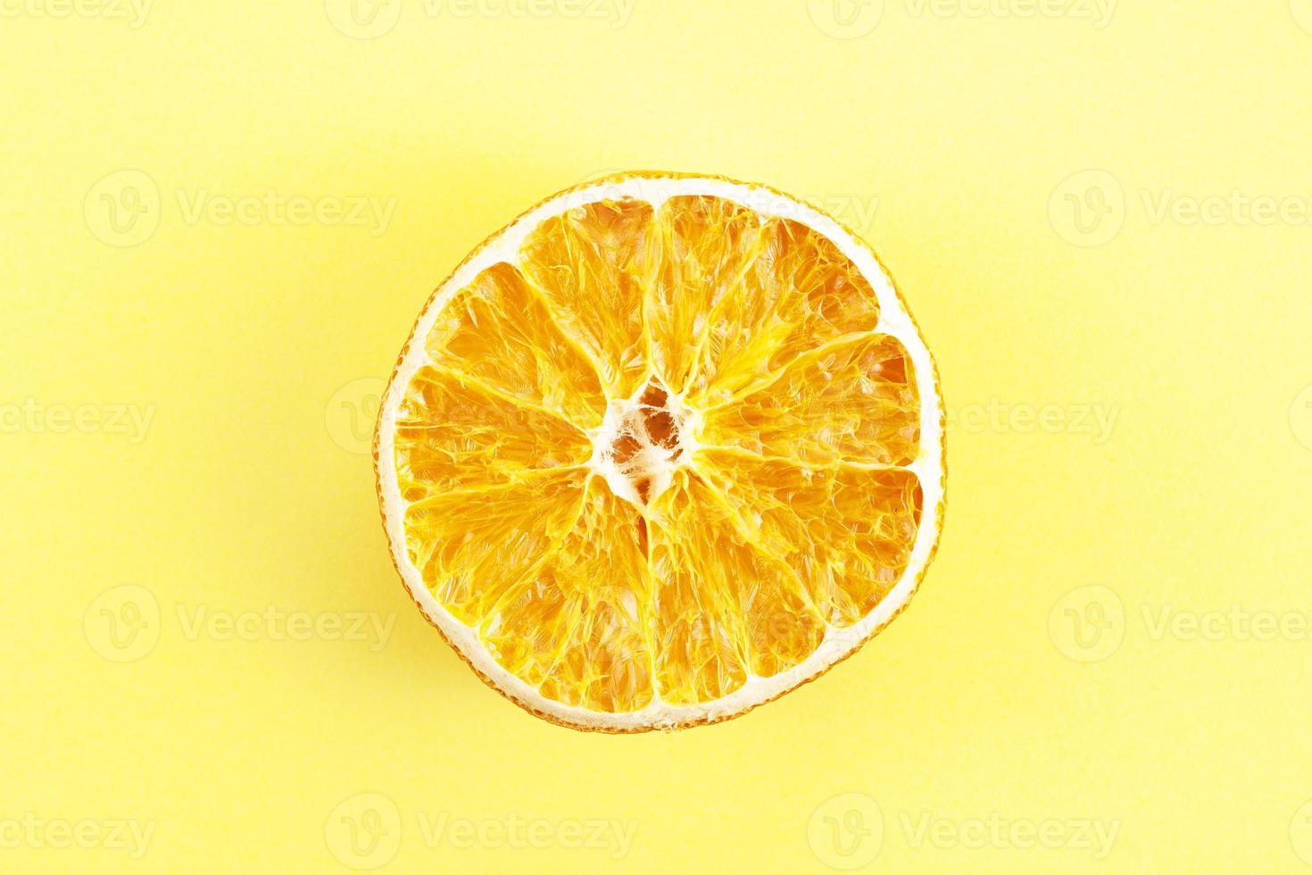 en bit torkad apelsin på gul bakgrund foto
