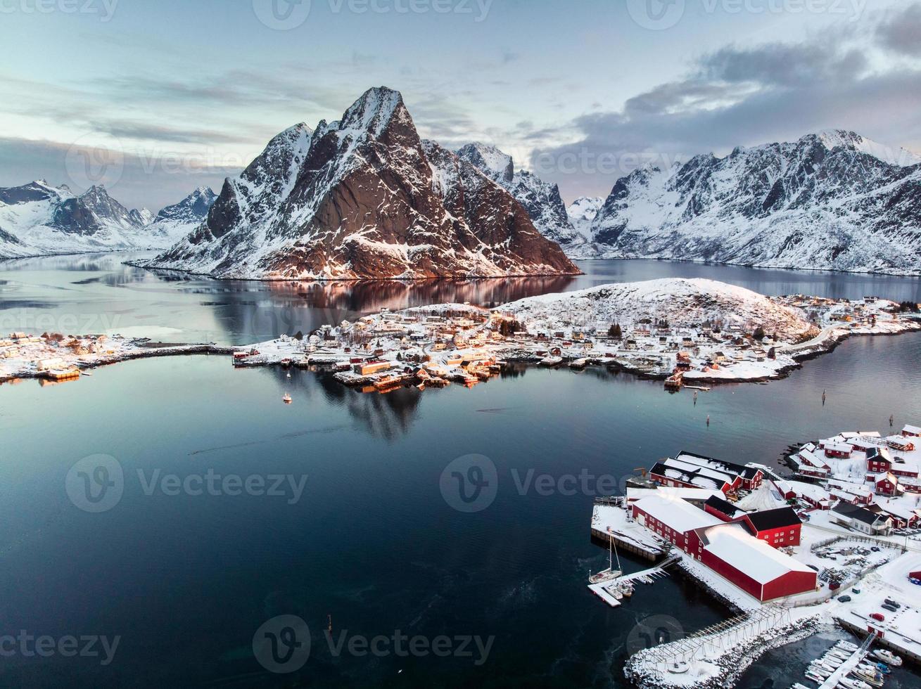 Flygfoto över fiskebyn i omgivna berg på vintersäsongen foto