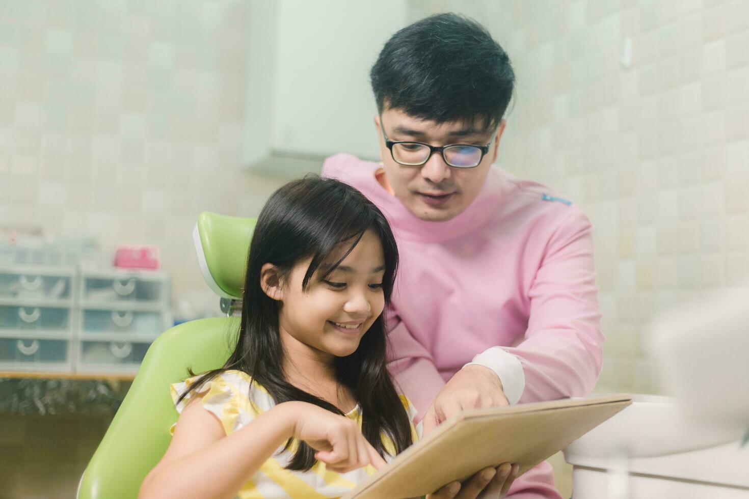 en leende flicka med tumme Uppfostrad har tänder undersökning på dental klinik. människor, medicin, stomatologi och hälsa vård begrepp foto