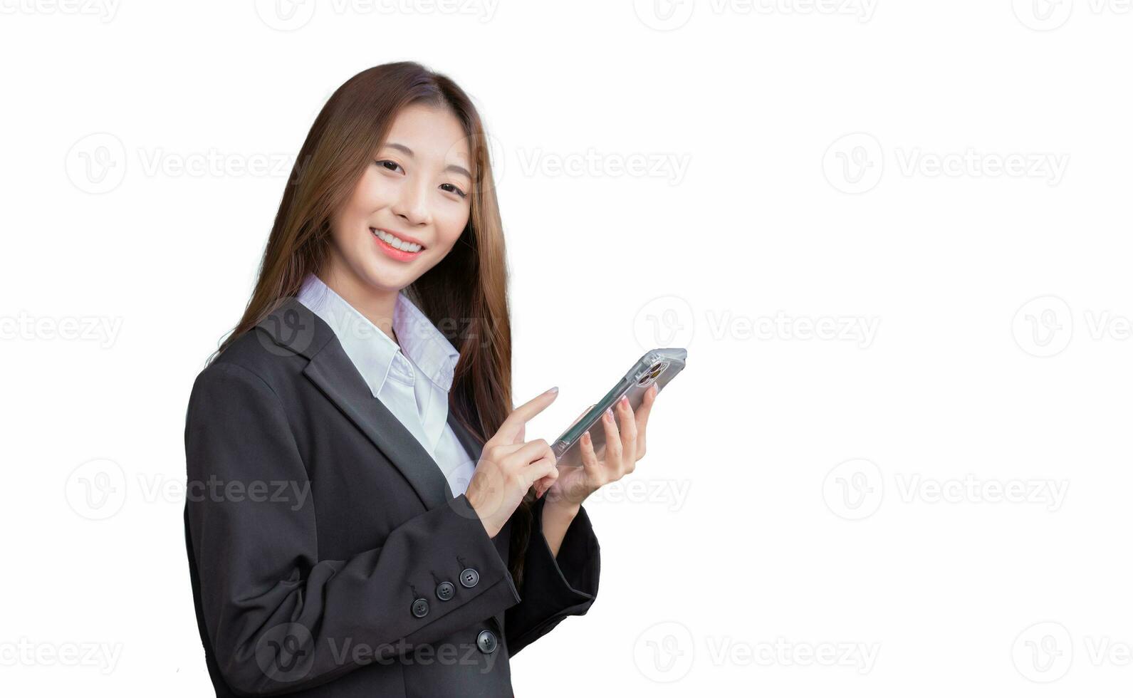 ung professionell asiatisk affärskvinna i en vit skjorta och mörk blå kostym är stående självsäkert leende medan använder sig av smartphone till kommunicera isolerat på vit Färg bakgrund. foto