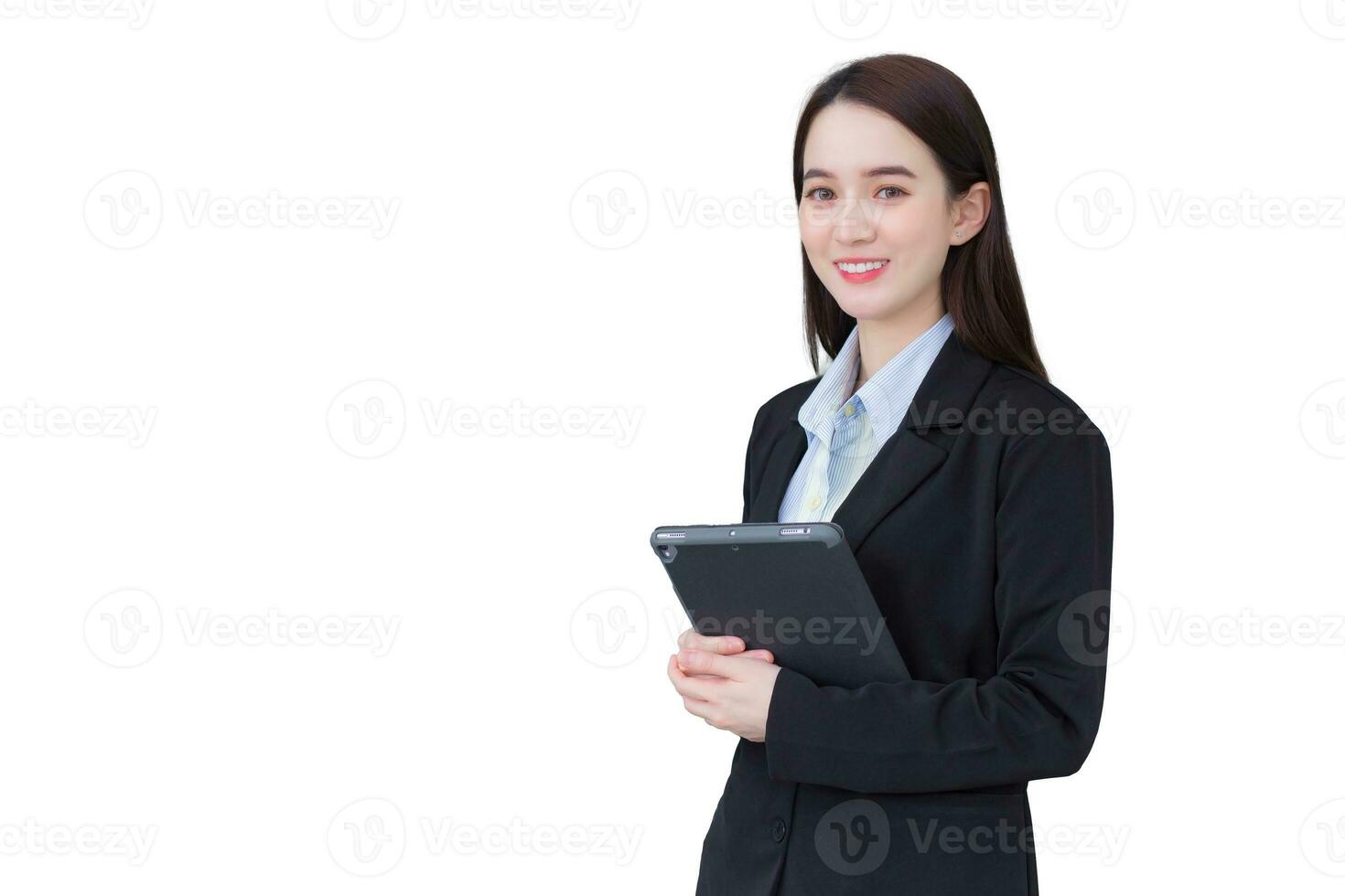 asiatisk professionell företag ung kvinna i svart kostym ler lyckligt stå och se på de kamera medan hon Arbetar och innehar läsplatta isolerat på vit bakgrund. foto