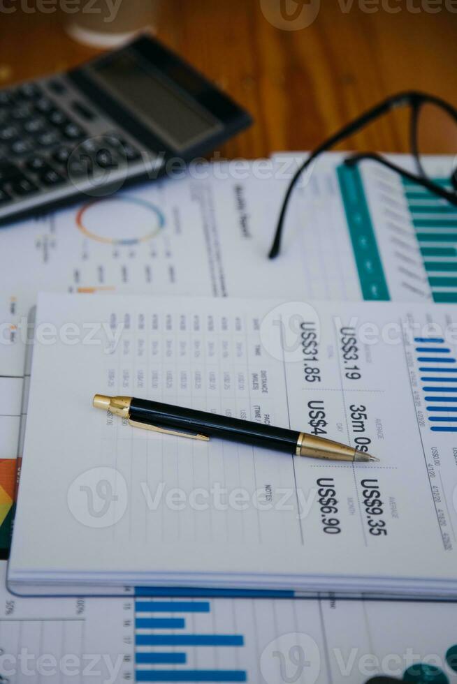 närbild av revisor som arbetar och analyserar finansiella rapporter projektredovisning med diagramgraf och kalkylator i modern kontorsekonomi och affärsidé. foto