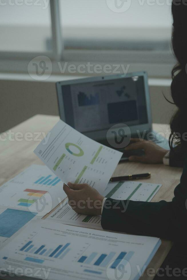 porträtt av ung asiatisk kvinna hand frilansare arbetar sitt jobb på dator surfplatta i moderna kontor. gör redovisningsanalysrapport fastighetsinvesteringsdata, finansiella och skattesystemkoncept. foto
