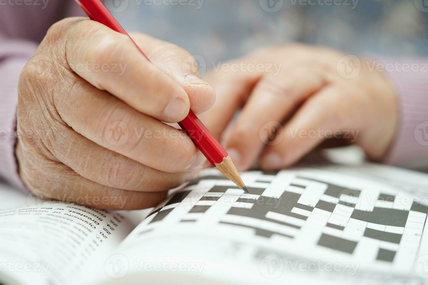 asiatisk äldre kvinna spelar sudoku pussel spel till öva hjärna Träning för demens förebyggande, alzheimers sjukdom. foto