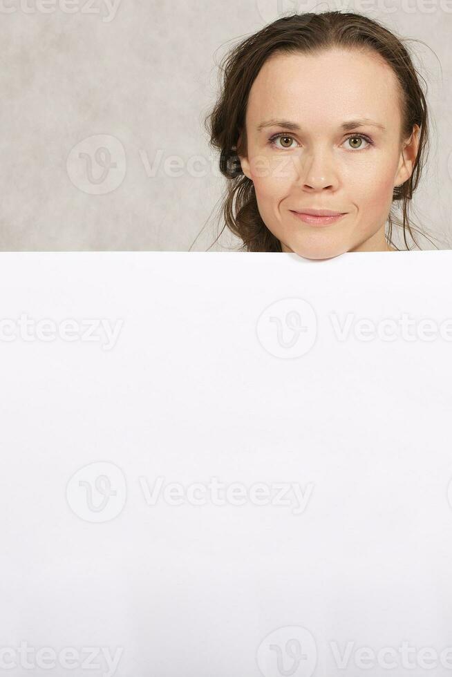 ung lady håller en vit ark av papper foto