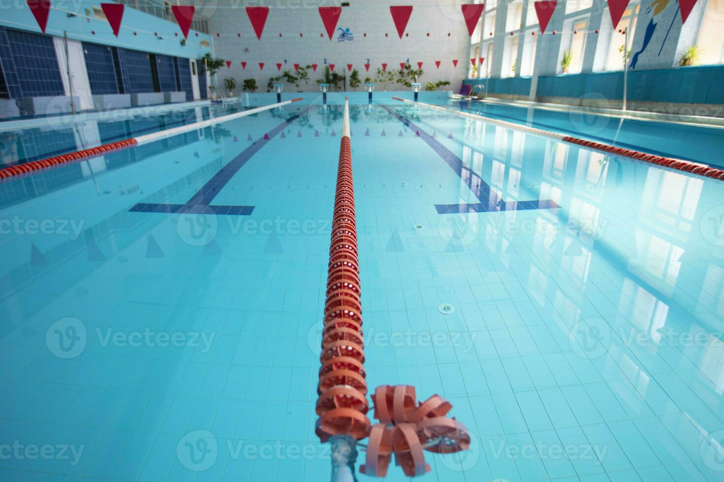 ett tömma sporter slå samman med en röd skilje väg. blå vatten i de simning slå samman. foto