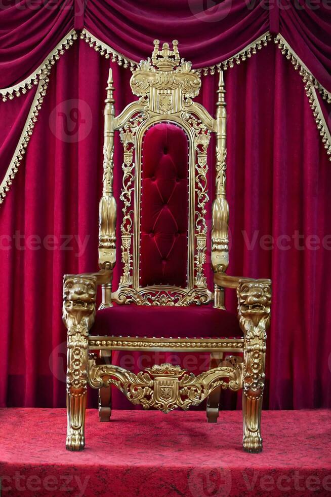 röd kunglig stol på en bakgrund av röd gardiner. plats för de kung. tron foto