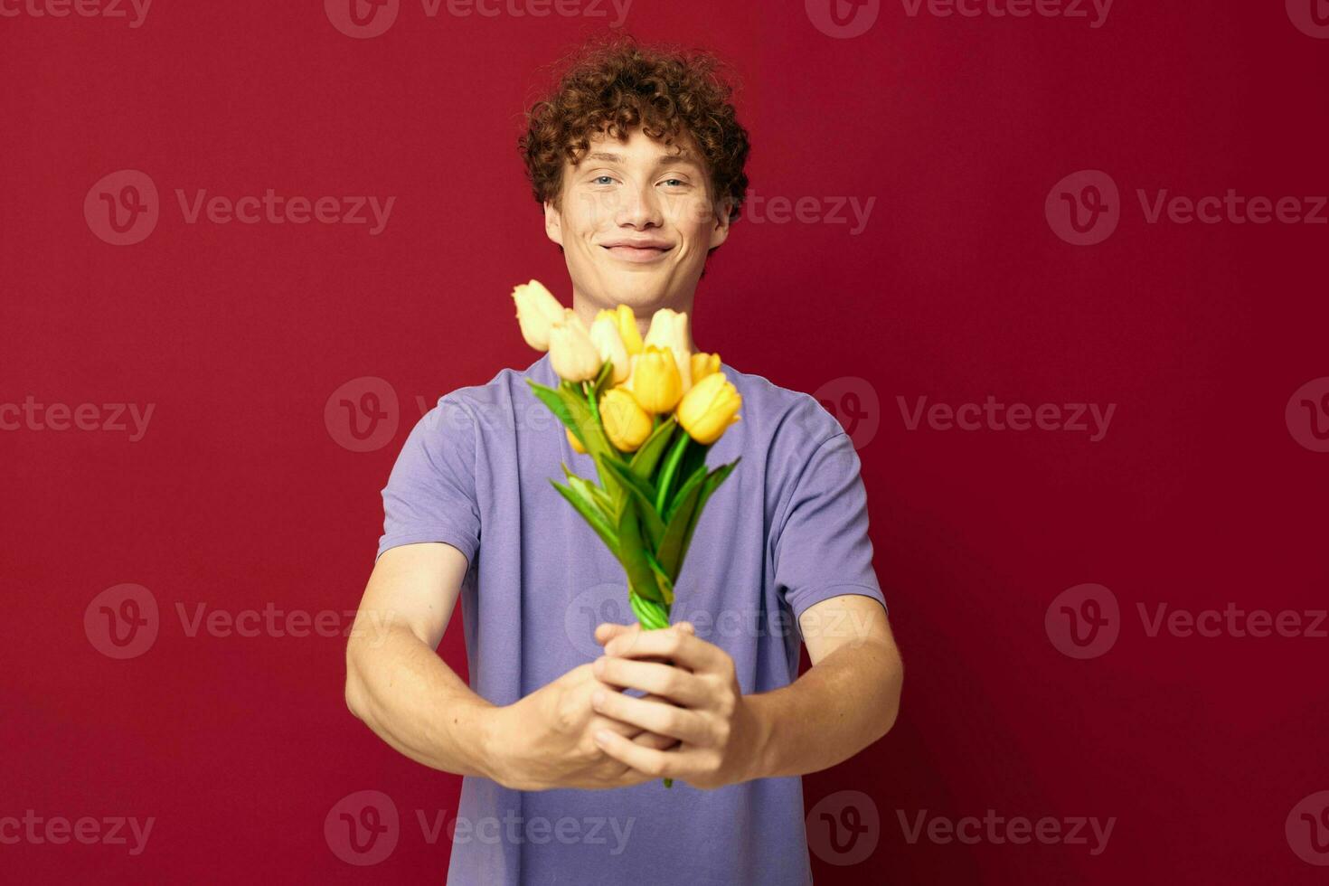 kinky kille röd hår i tillfällig ha på sig bukett av blommor gåva röd bakgrund oförändrad foto