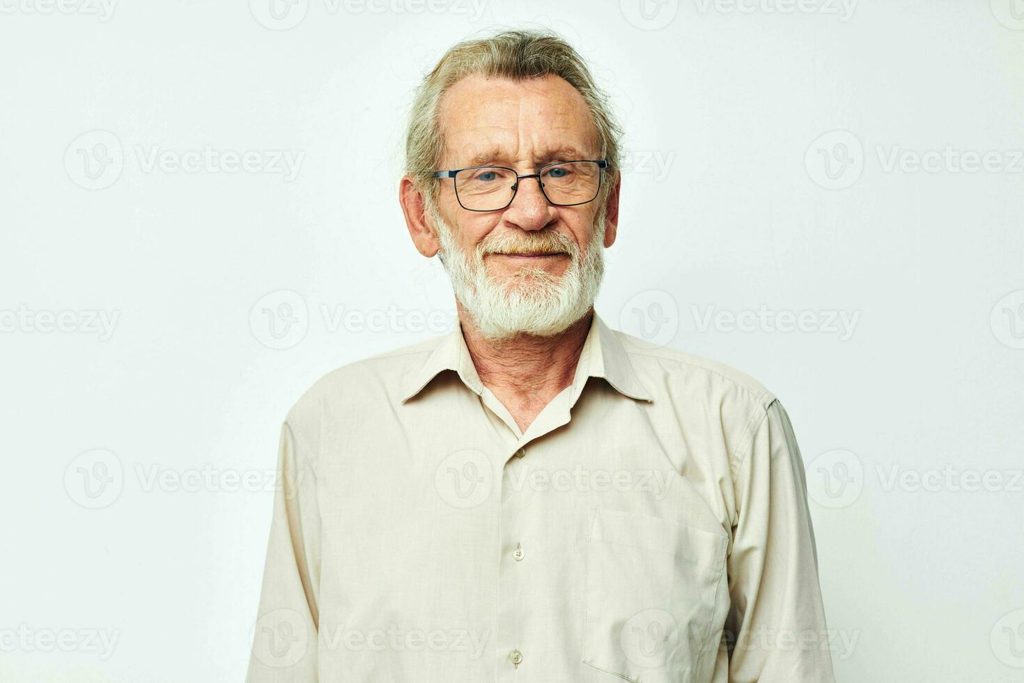 porträtt äldre man med en grå skägg i en skjorta och glasögon ljus bakgrund foto