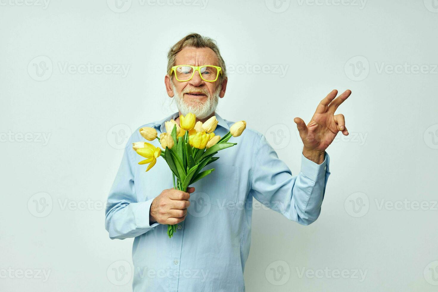 Foto av pensionerad gammal man en bukett av blommor med glasögon som en gåva ljus bakgrund