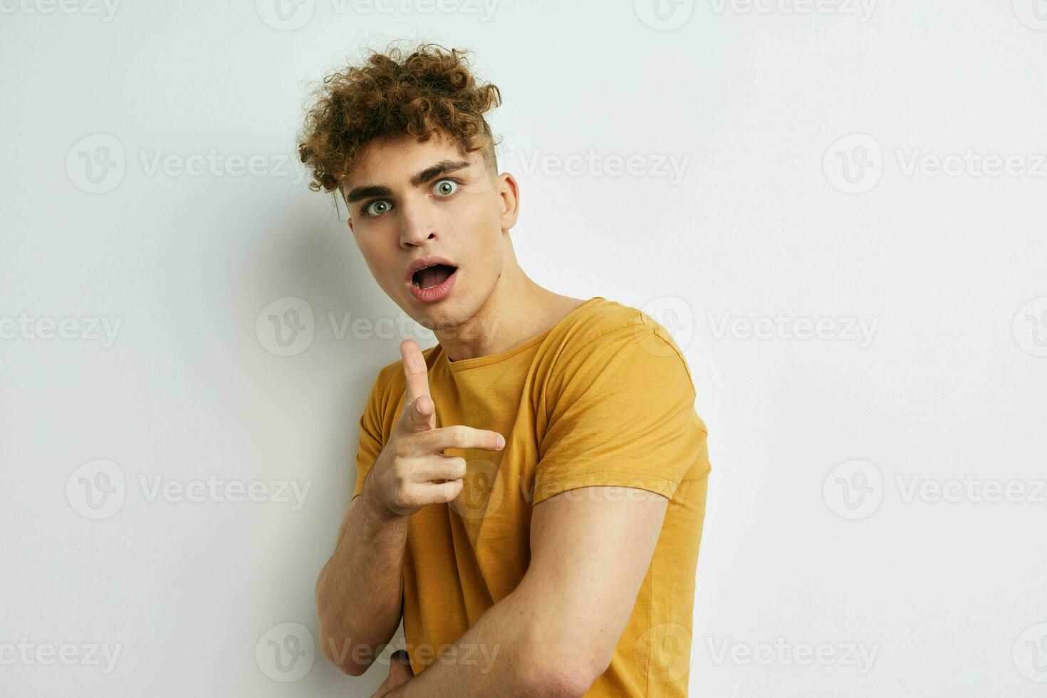 attraktiv man i gul t-tröjor gest händer känslor livsstil oförändrad foto