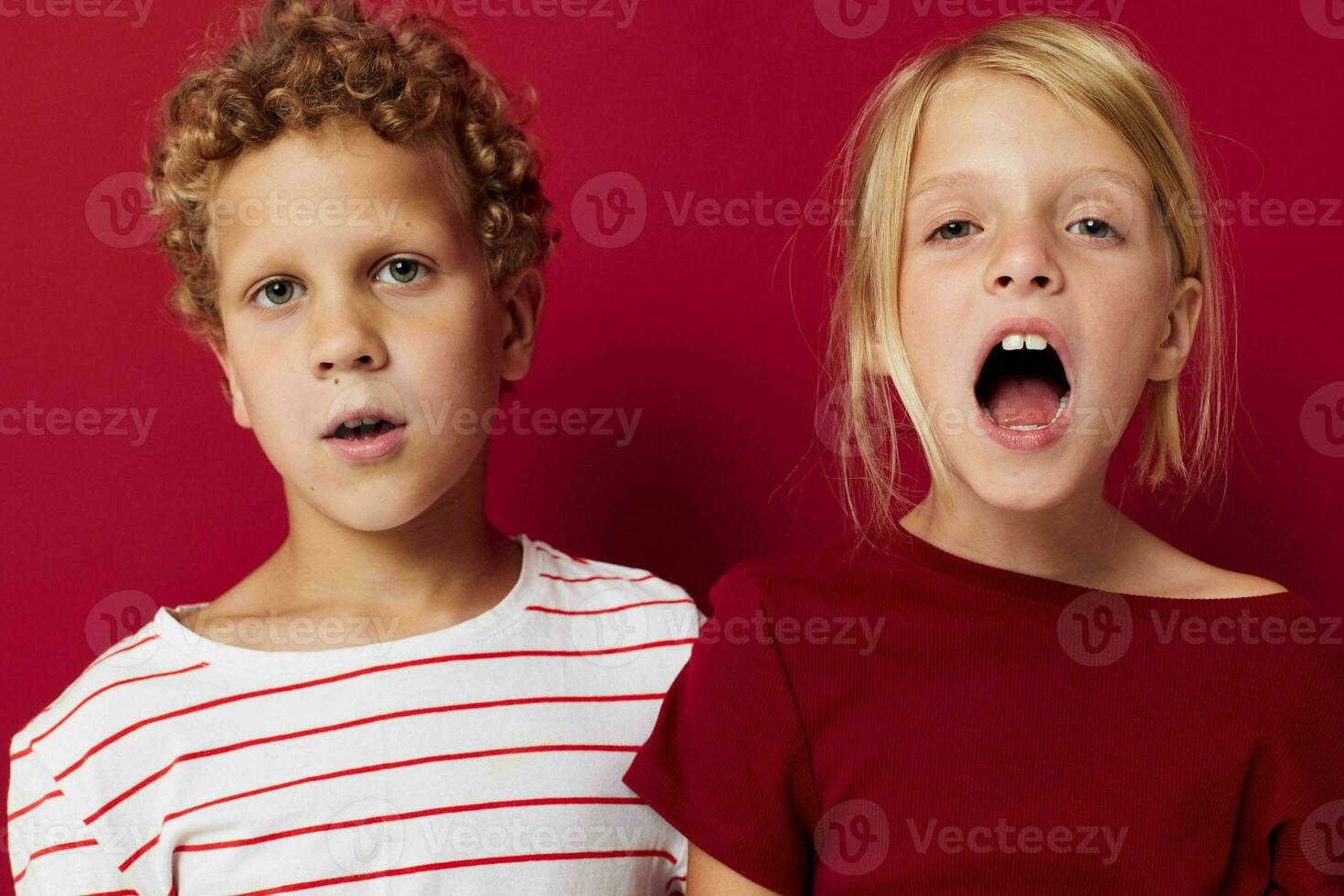 söt förskola barn känslor stå sida förbi sida i varje dag kläder röd bakgrund foto
