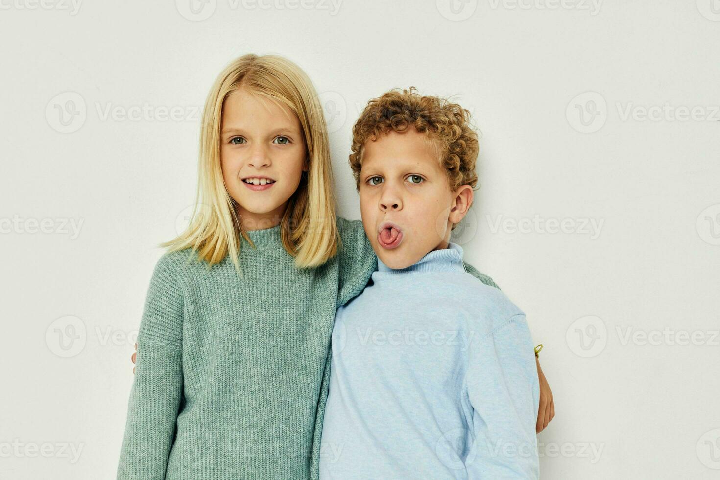 Foto av två barn i flerfärgad tröjor Framställ för roligt ljus bakgrund