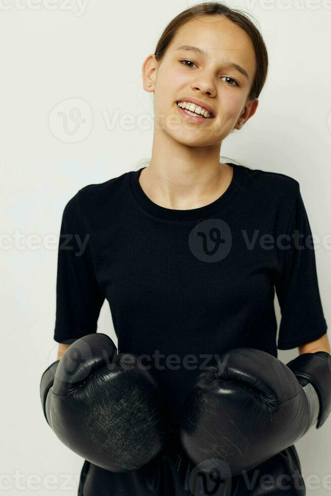 atletisk kvinna i boxning handskar i svart byxor och en t-shirt isolerat bakgrund foto