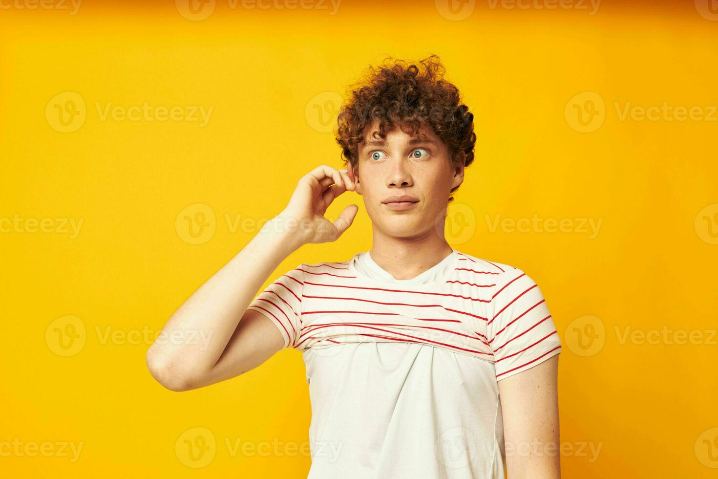 porträtt av en ung lockigt man sätta på en randig t-shirt Framställ isolerat bakgrund oförändrad foto