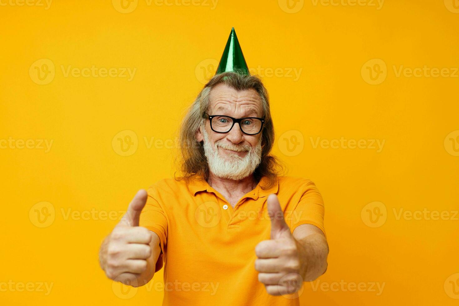porträtt äldre man i en gul t-shirt med en keps på hans huvud roligt gul bakgrund foto