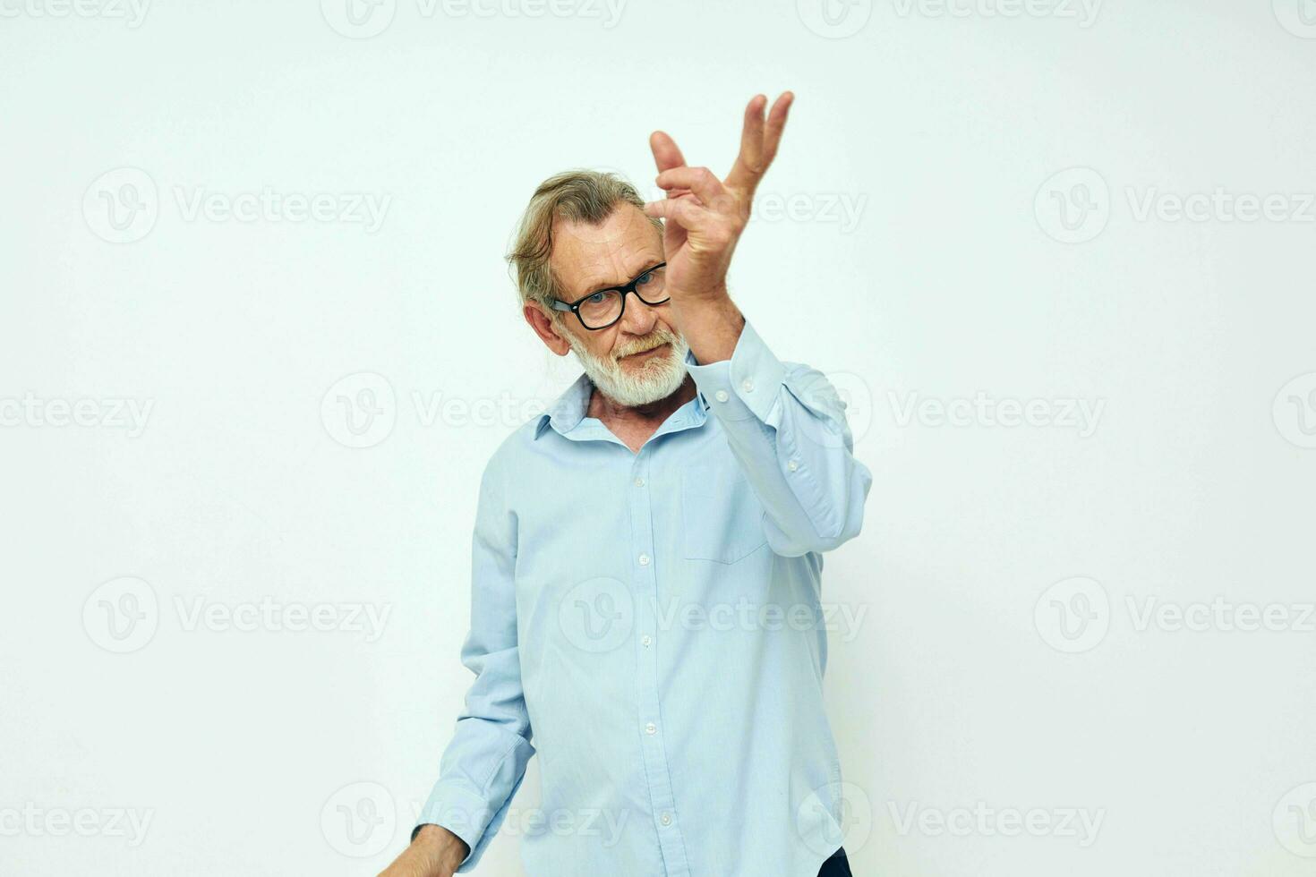 porträtt av Lycklig senior man i blå shirts gester med hans händer ljus bakgrund foto