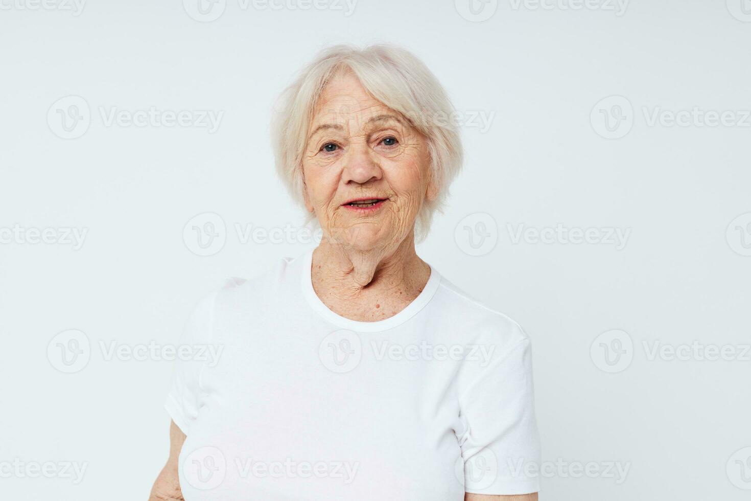 porträtt av leende äldre kvinna vit t-shirt isolerat bakgrund foto