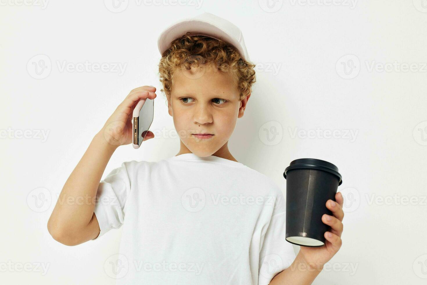 Foto porträtt lockigt liten pojke talande på de telefon med en svart glas isolerat bakgrund oförändrad