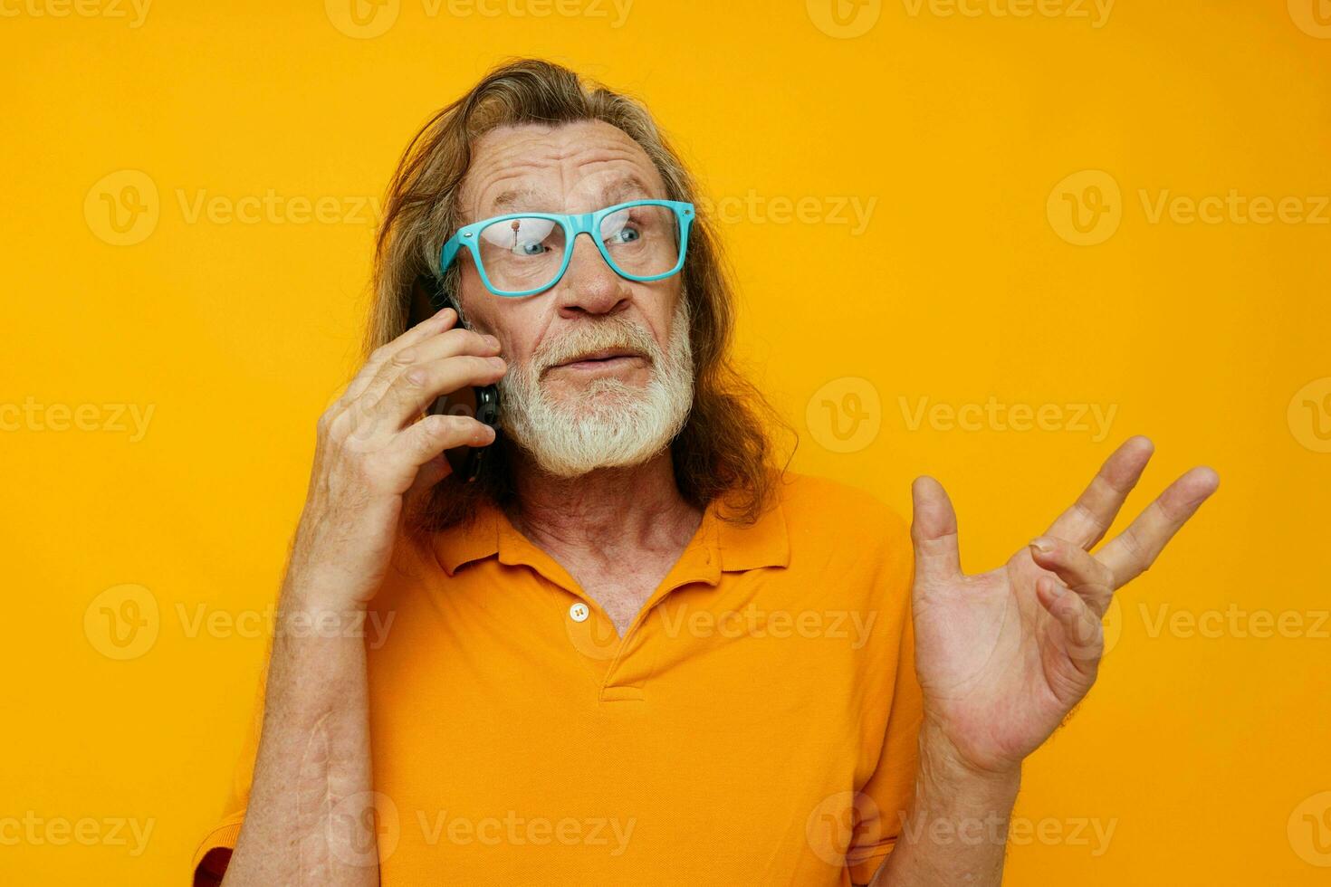 gammal man i gul t-tröjor och glasögon talande på de telefon isolerat bakgrund foto