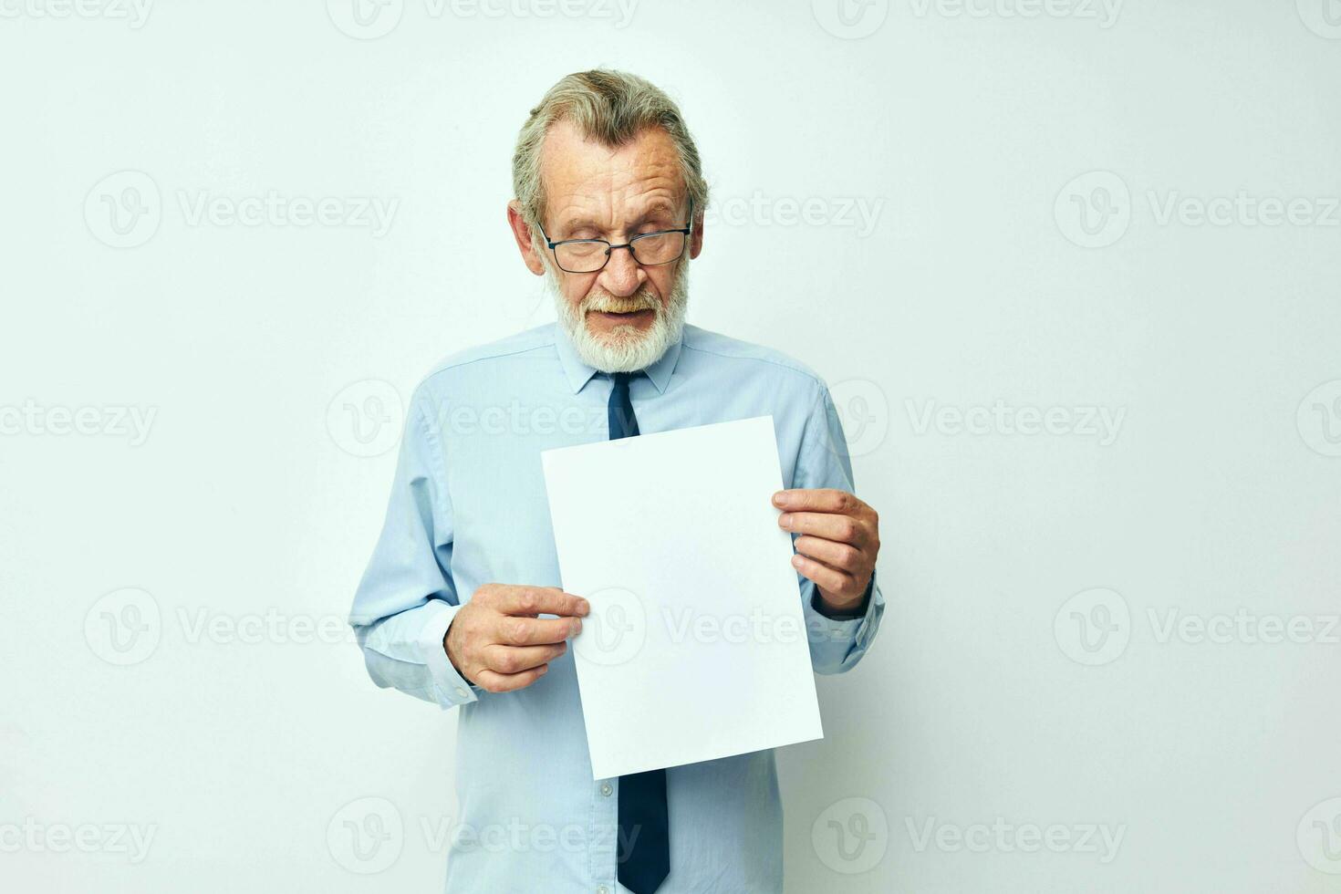 Foto av pensionerad gammal man innehav dokument med en ark av papper ljus bakgrund