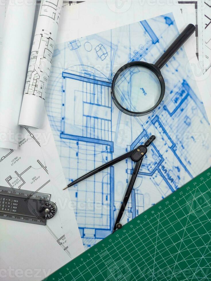 arkitekt ingenjör kontor skrivbord. plan planer och hus modell med linjal, kompass, och förstoringsglas glas foto