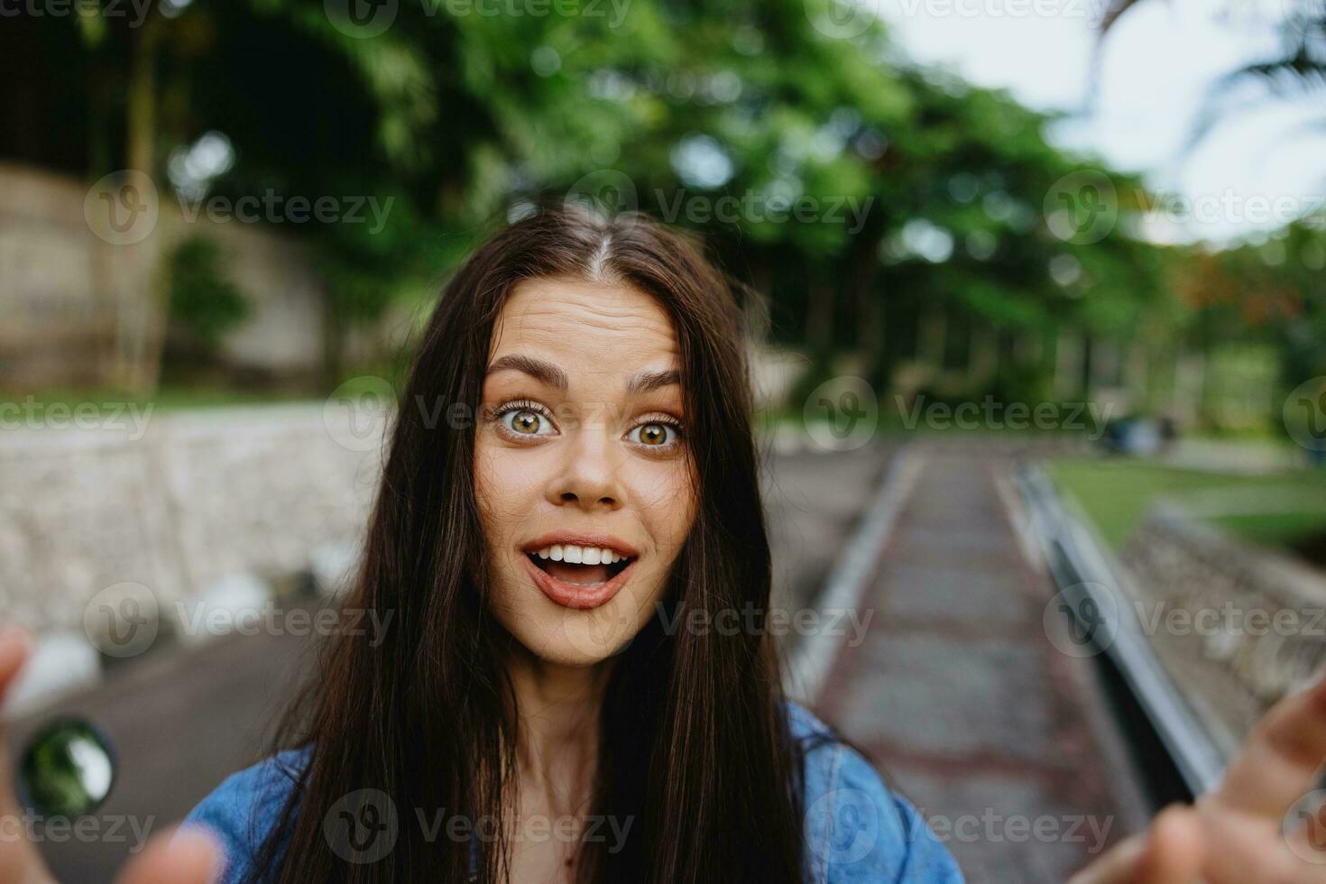 porträtt av en kvinna brunett leende med tänder gående utanför mot en bakgrund av handflatan träd i de tropikerna, sommar semester och utomhus- rekreation, de sorglös livsstil av en frilans studerande. foto