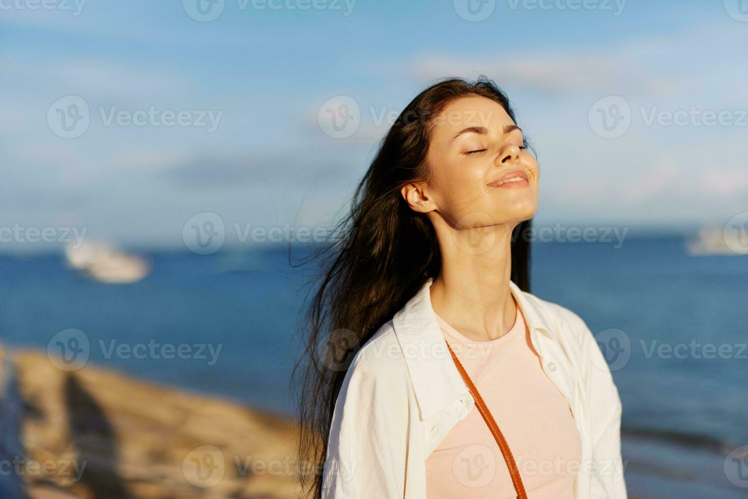 kvinna skönhet leende med tänder frihet på semester promenader längs de strand nära de hav i bali solnedgång, Lycklig resa och semester, solnedgång ljus, flygande hår, njutning av avslappning och harmoni foto