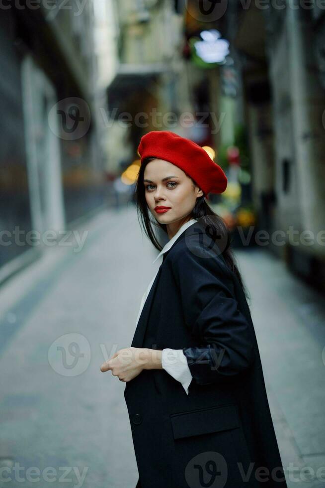 mode kvinna leende med tänder porträtt gående turist i eleganta kläder i jacka med röd mun gående ner smal stad gata flygande hår, resa, filmiska Färg, retro årgång stil. foto