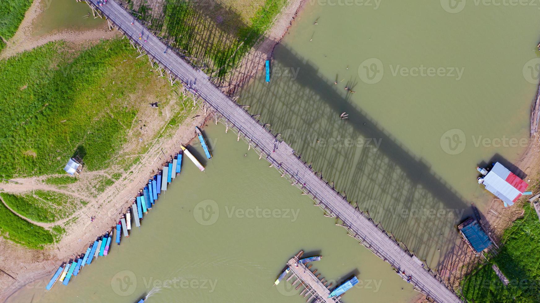 Flygfoto ovanifrån av träbro med turnébåt i Thailand foto