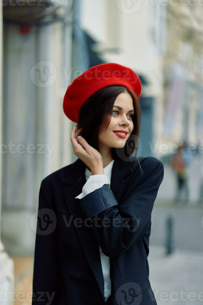 mode kvinna leende vår gående i de stad i eleganta kläder med röd mun och röd basker, resa, filmiska Färg, retro årgång stil, urban mode livsstil. foto