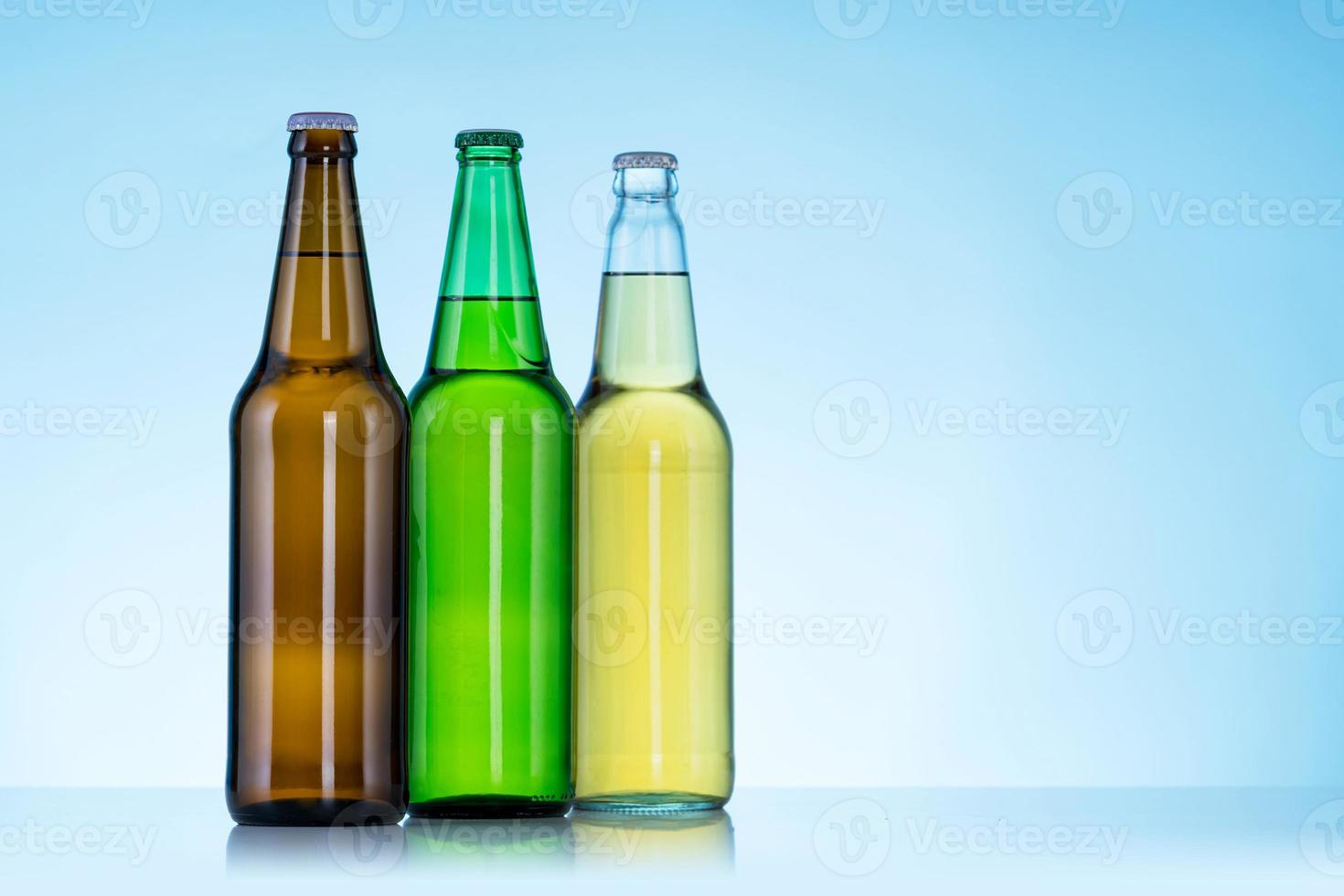 grupp av tre flaskor öl på blå bakgrund foto