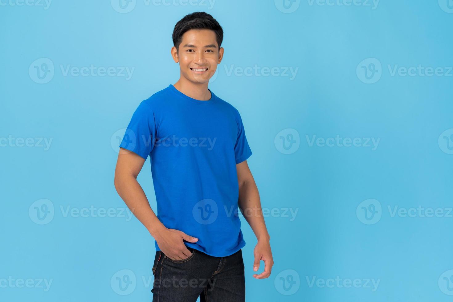 ung man i blå t-shirt isolerad på blå bakgrund foto