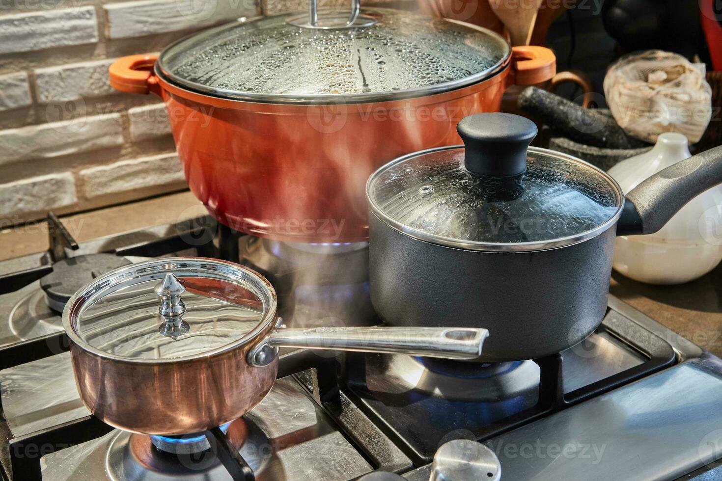 grytor med matlagning i köket på gasspis foto