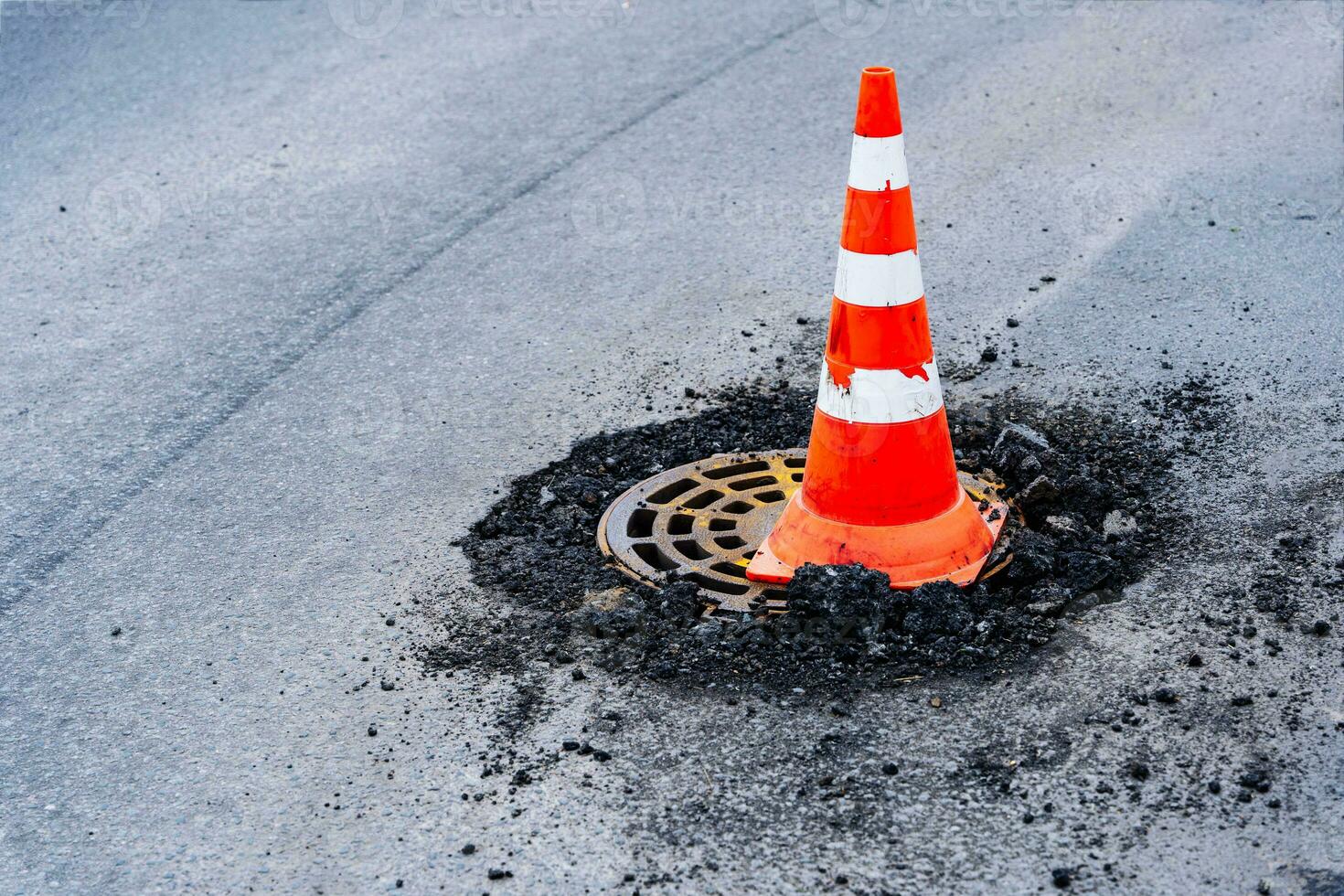 signal trafik kon på en felaktig avlopp manhål på en stad motorväg foto