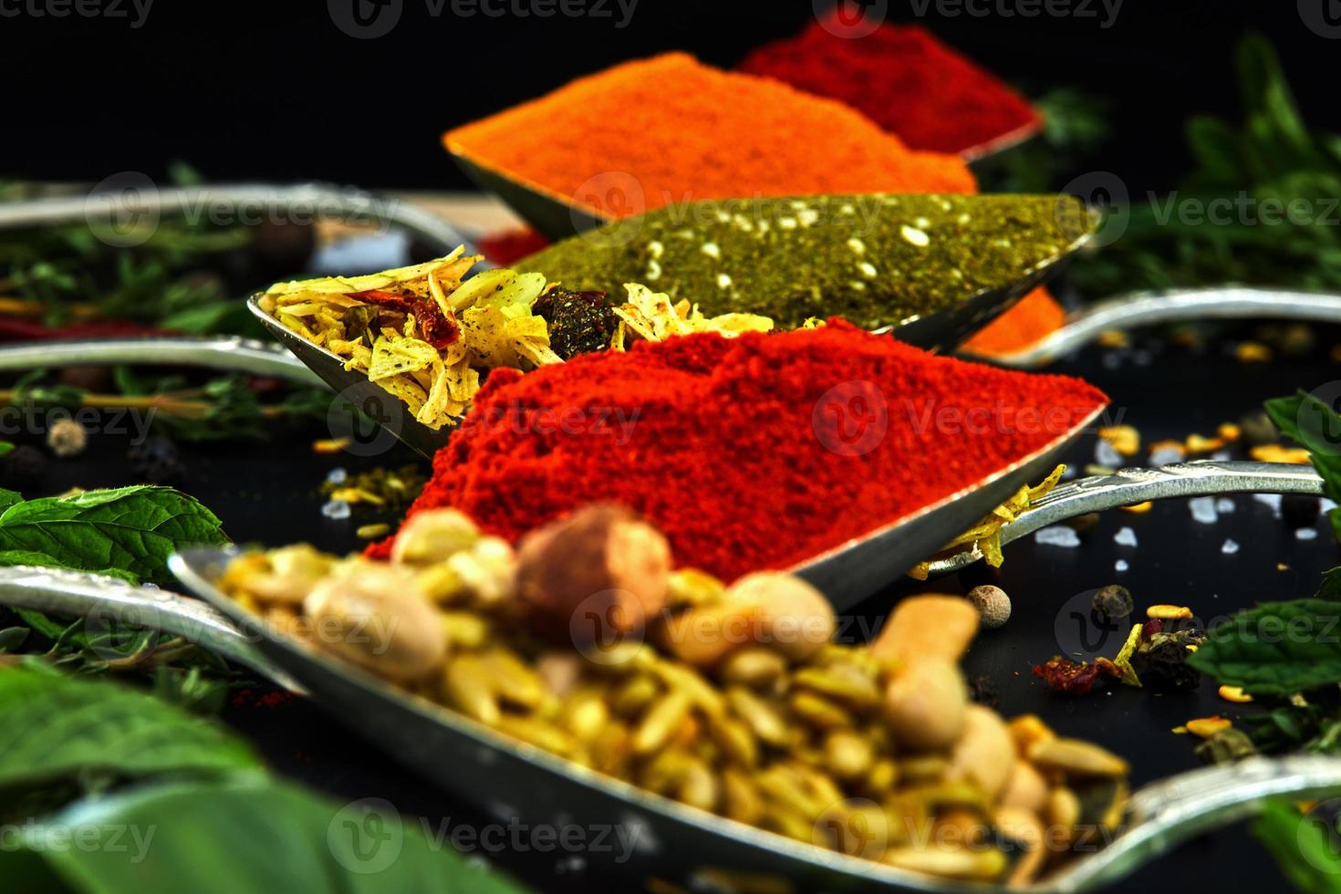 färgglada olika örter och kryddor för matlagning på mörk bakgrund foto